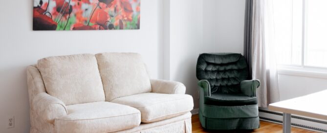 Salon avec canapé, fauteuil vert et peinture de fleurs